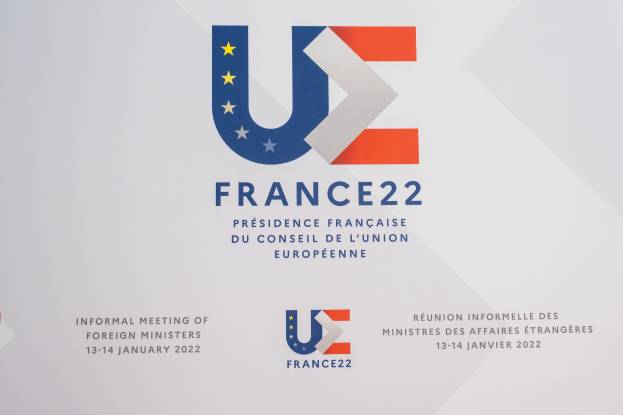 Plakat für die "Frankreich 22 - Informelle Tagung der Außenminister" mit dem Logo der Europäischen Union, das einen blauen Kreis mit einem weißen Stern und schwarzen zentrierten Text zeigt.