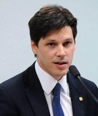 Ein Mann im Anzug und Krawatte spricht in ein Mikrofon, wahrscheinlich um die Genehmigung eines Gesetzes zur Internet-Sperre durch die Regierung zu verkünden.