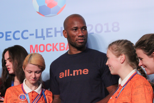 Eine Gruppe von Menschen mit Medaillen steht auf einer Bühne mit einem Banner, das Text und einen Fußball im Hintergrund zeigt, was die 2018 FIFA WM Russland anzeigt.