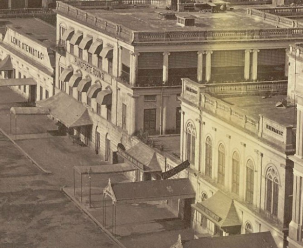 Altes Schwarz-Wei├č-Foto einer Stra├če mit Geb├Ąuden, Fenstern, Pfeilern, Namensschildern, Schuppen und Masten.