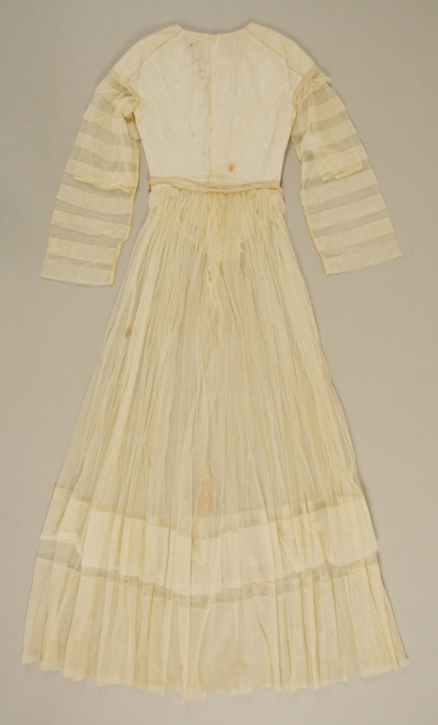 Ein weißes, langärmeliges Kleid mit einer gerafften, bodenlangen Schleppe auf einem weißen Hintergrund, das eine hohe Taille, einen Volumenstoff und einen dezenten Glanz aufweist.