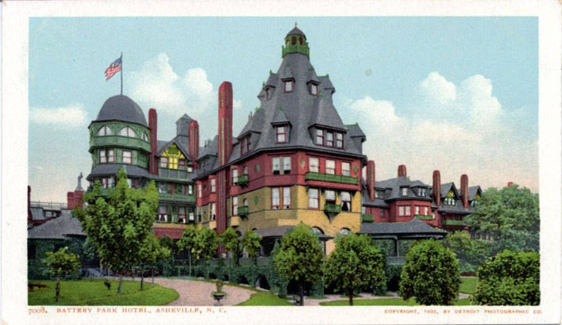 Schwarz-weiß-Postkarte des Battery Park Hotels in Asheville, North Carolina, zeigt ein großes Gebäude mit einer Flagge oben drauf, umgeben von Bäumen, Pflanzen, Gras und einem Weg, mit Himmel im Hintergrund und Text unten.