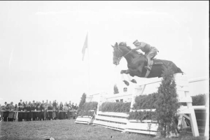 Schwarzes und weißes Foto eines Pferdes und seines Reiters, die über ein Hindernis springen, bei den Royal Ascot Horse Trials 1953.