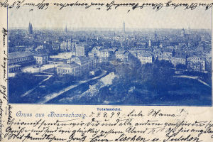 Alte Postkarte zeigt eine Stadtansicht von einem Hügel mit Gebäuden, Bäumen und handgeschriebener Text.