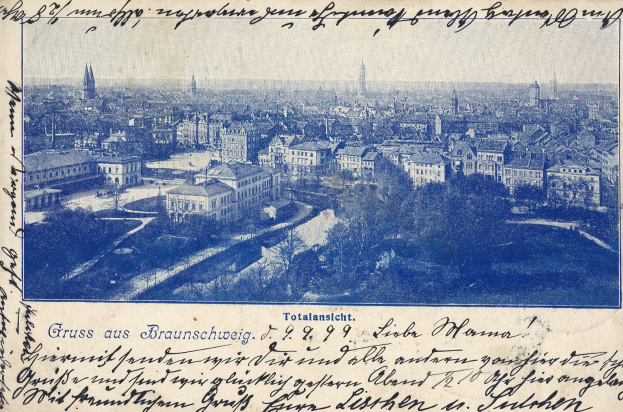 Alte Postkarte zeigt eine Stadtansicht von einem Hügel mit Gebäuden, Bäumen und handgeschriebener Text.