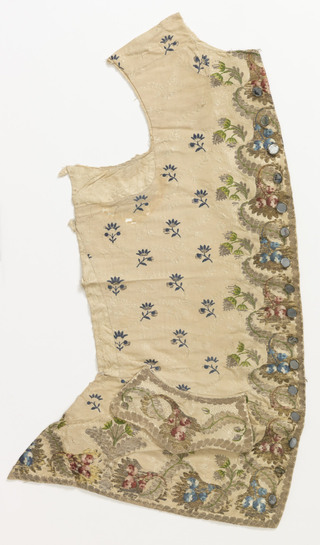 Ein cremefarbenes Blumenkleid mit aufwendiger Stickerei auf weißem Hintergrund.