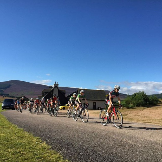 Eine Gruppe von Menschen, die Fahrrad fährt, mit einem klaren Himmel im Hintergrund.