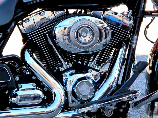 Eine Sammlung von Motorradteilen, darunter ein Motor, ein K√ľhler, ein Auspuffrohr, G√§nge, Stangen, Muttern und Dr√§hte.