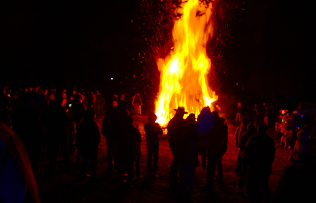 Eine Gruppe von Menschen vor einem Feuer.