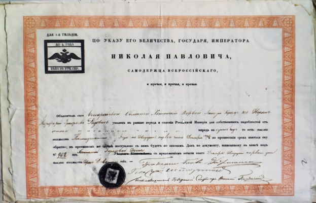 Altes Zertifikat mit einem Stempel auf einer Oberfläche, mit sichtbarem Text.