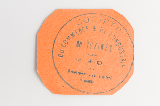 Ein oranges Etikett mit den schwarzen Buchstaben "Societe du Commerce et de l'Industrie" auf einem weißen Hintergrund.