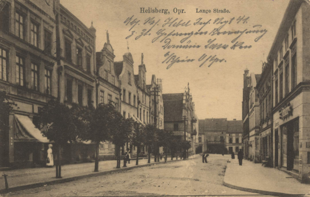 Ein altes Schwarz-Weiß-Foto einer Stadtstraße namens Heilberg, Opr. Lange Straße, mit Gebäuden, Bäumen, Pfählen, Menschen und Himmel.