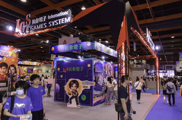 Menschen gehen durch einen Konferenzsaal auf einer Spielemesse in China, einige tragen Taschen und halten Gegenstände, mit Displaytafeln, Deckenbeleuchtung und Teppichboden.