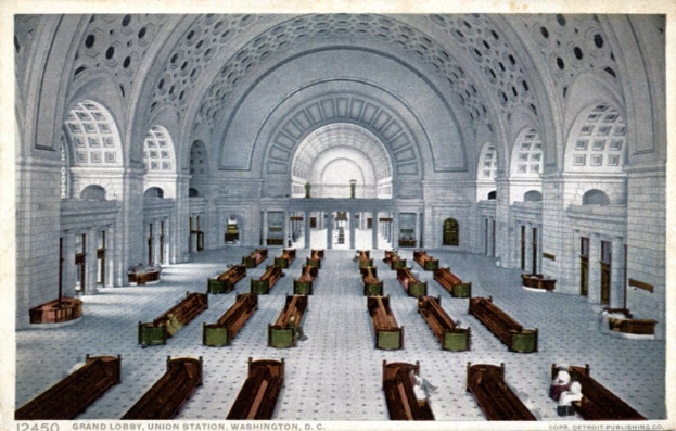 Großer Eingangsbereich des Union Station, Washington, D.C., mit hohen Decken, zahlreichen Bänken, tragenden Säulen, gewölbten Fenstern und prächtigen architektonischen Details.