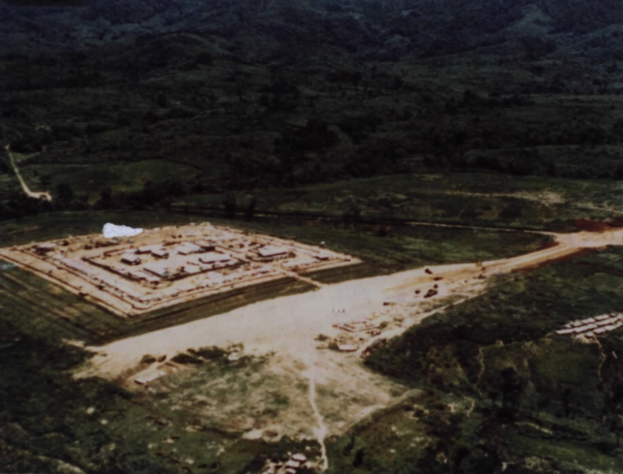 Luftaufnahme eines großen Gebäudes auf einem Feld umgeben von Bäumen und Bergen mit dem Text "Pueblo Bonito National Monument" unten.