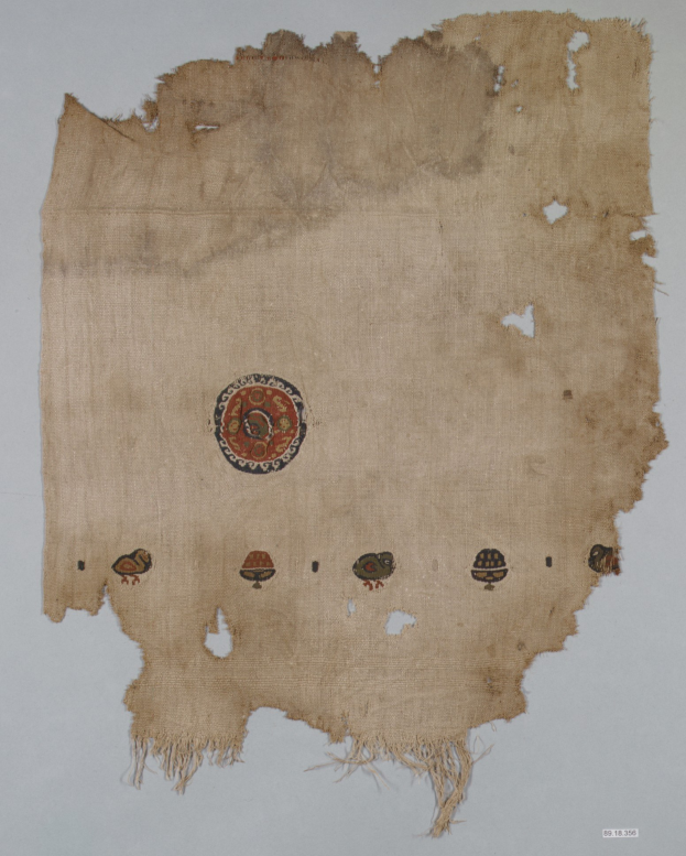 Ein Stück Stoff mit einem leuchtenden, detailreichen kreisförmigen Design, das aus verschiedenen Formen wie Kreisen, Quadraten und Dreiecken besteht, vor einem weißen Hintergrund.